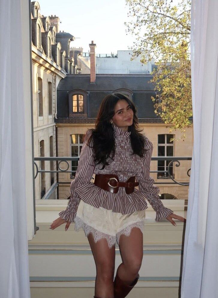 Dila of Unravel by Dila leaning at an open window