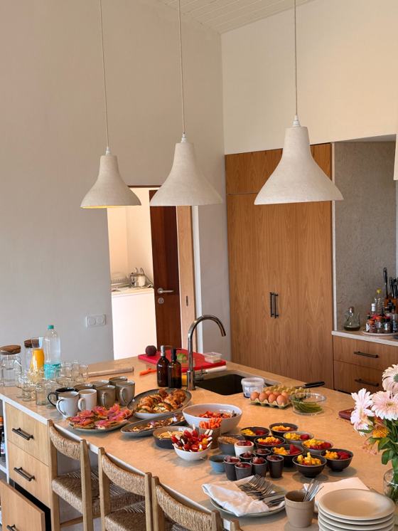 A long kitchen counter laid with dishes ready to share