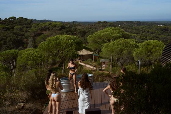 Women on a wooden deck among the umbrella pines of Comporta